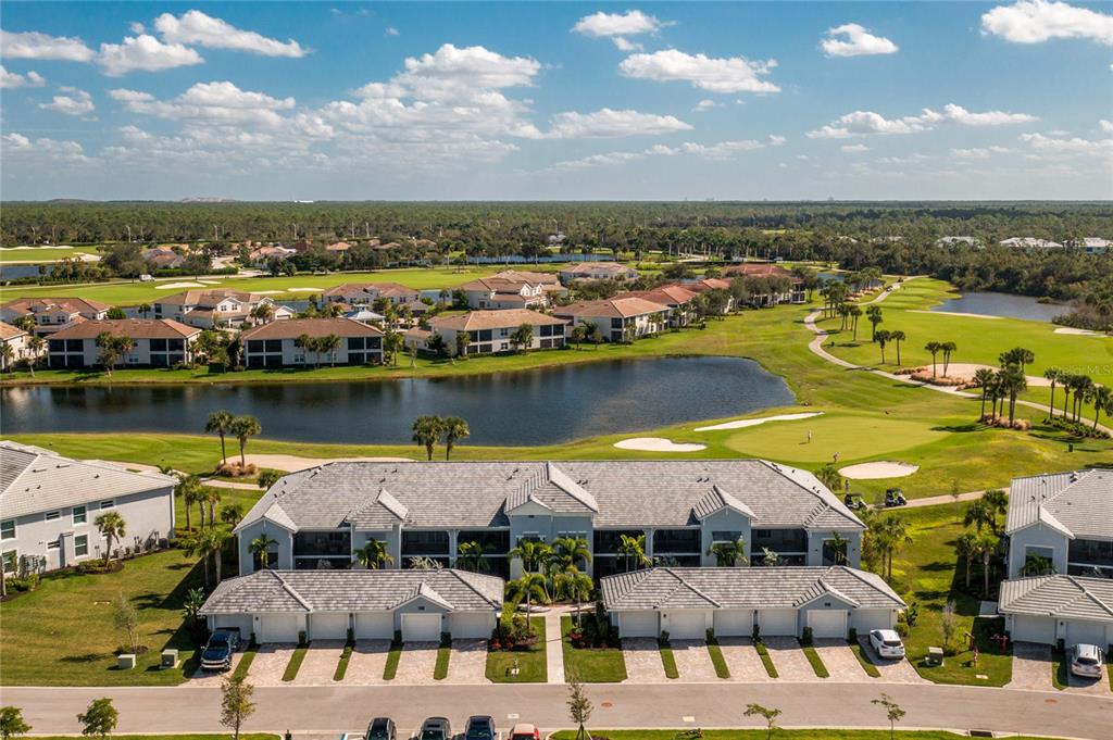 an aerial view of residential houses with outdoor space and lake view