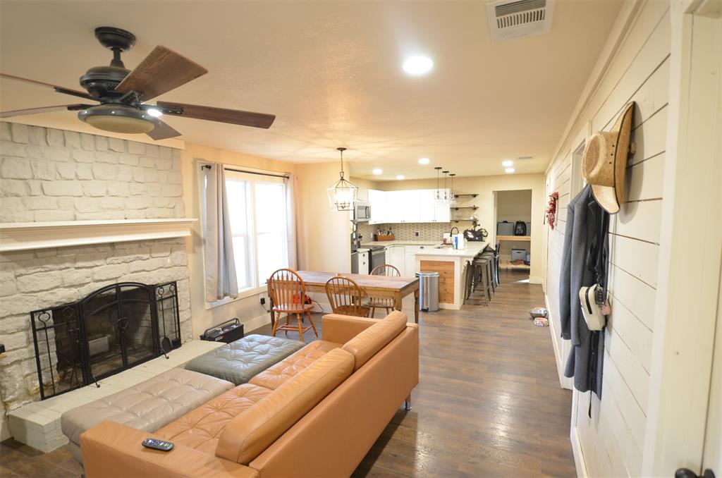 a living room with stainless steel appliances kitchen island furniture and a fireplace