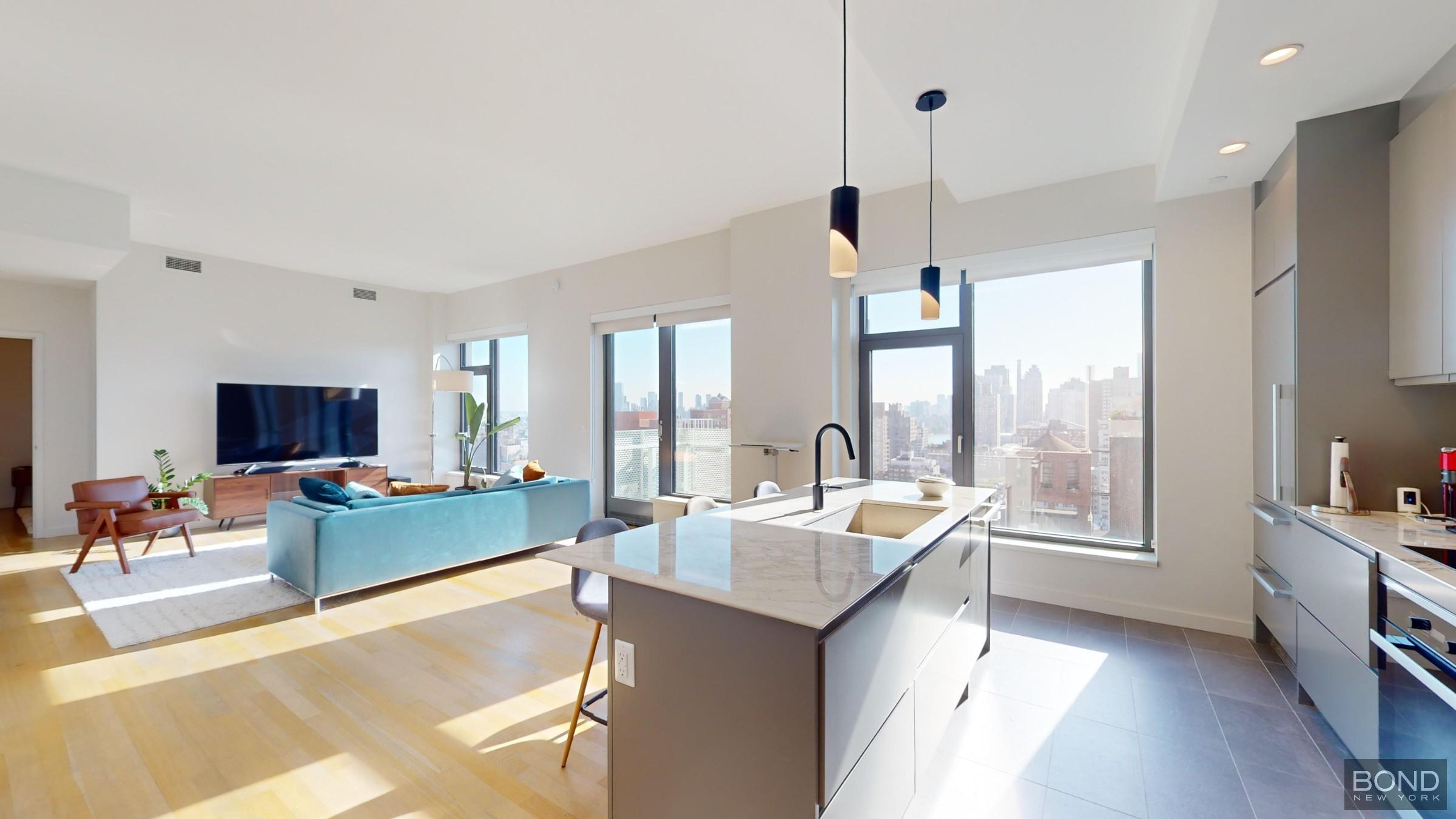 a large living room with a large window a table and chairs