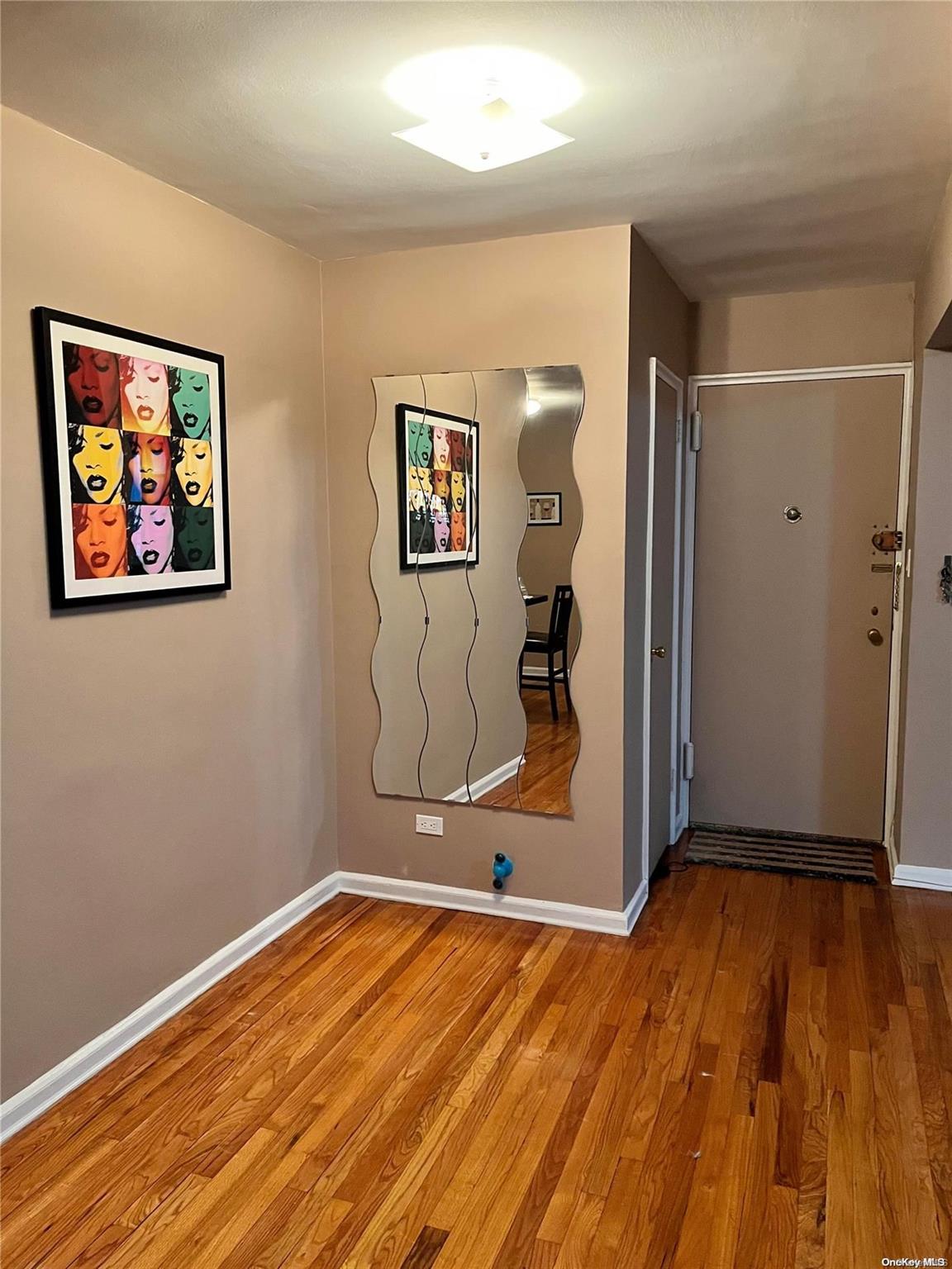 a view of a room with wooden floor and a ceiling fan