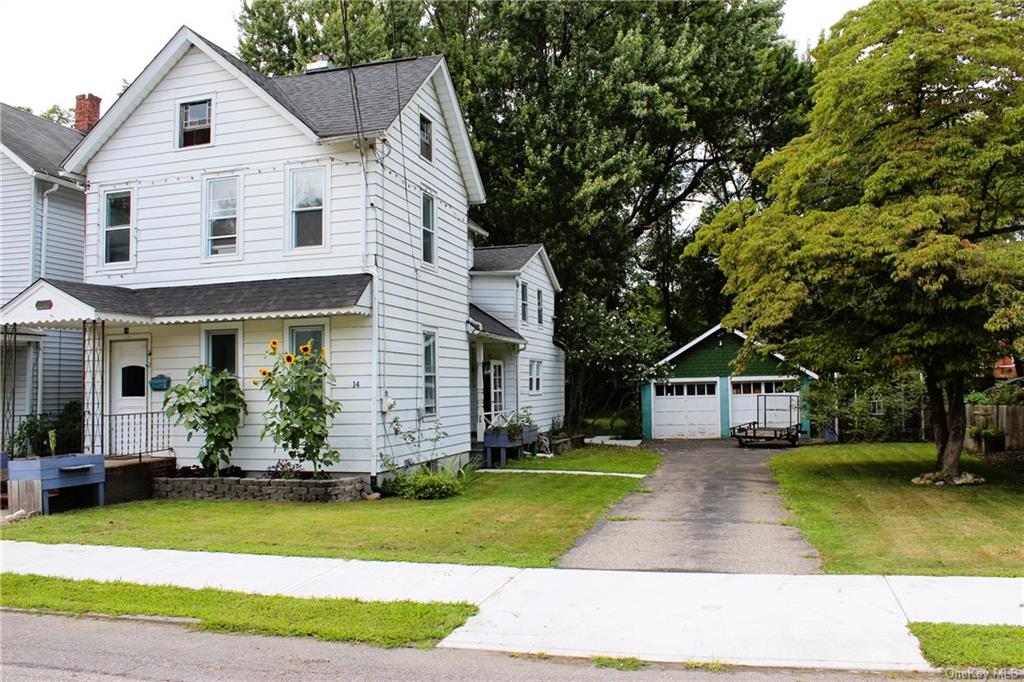 View of front of property with an outbuilding, a garage, and a front yard