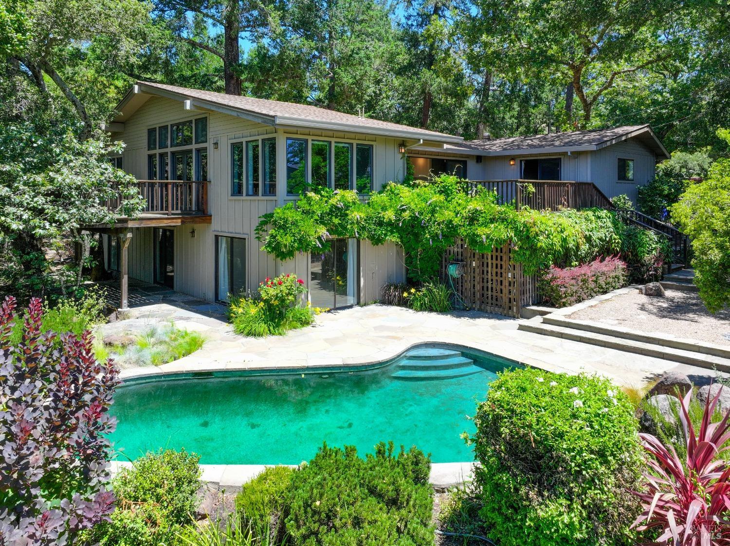 a view of a house with a yard and potted plants