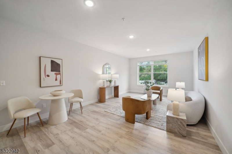 a living room with furniture a table and a large window