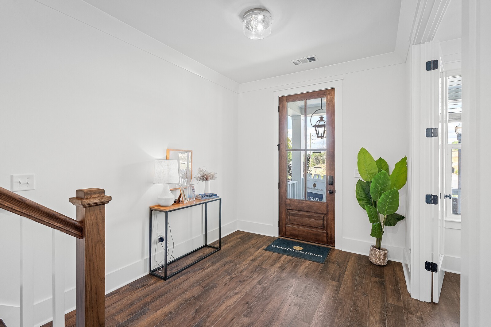 a view of a hallway to room with wooden floor and stairs