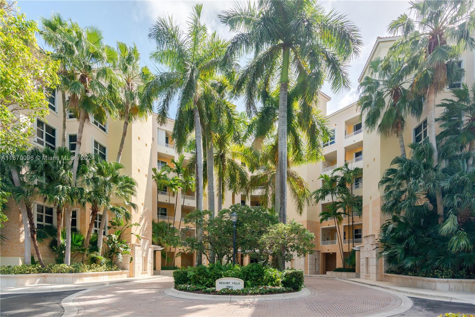 a front view of multi story residential apartment building with yard and green space