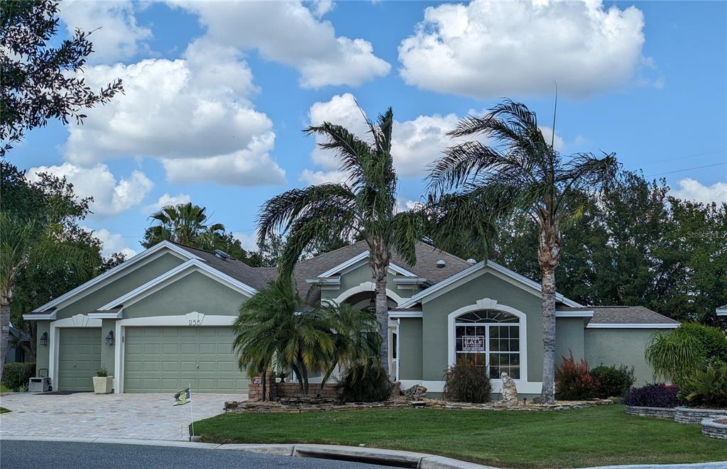 a front view of a house with a garden and trees