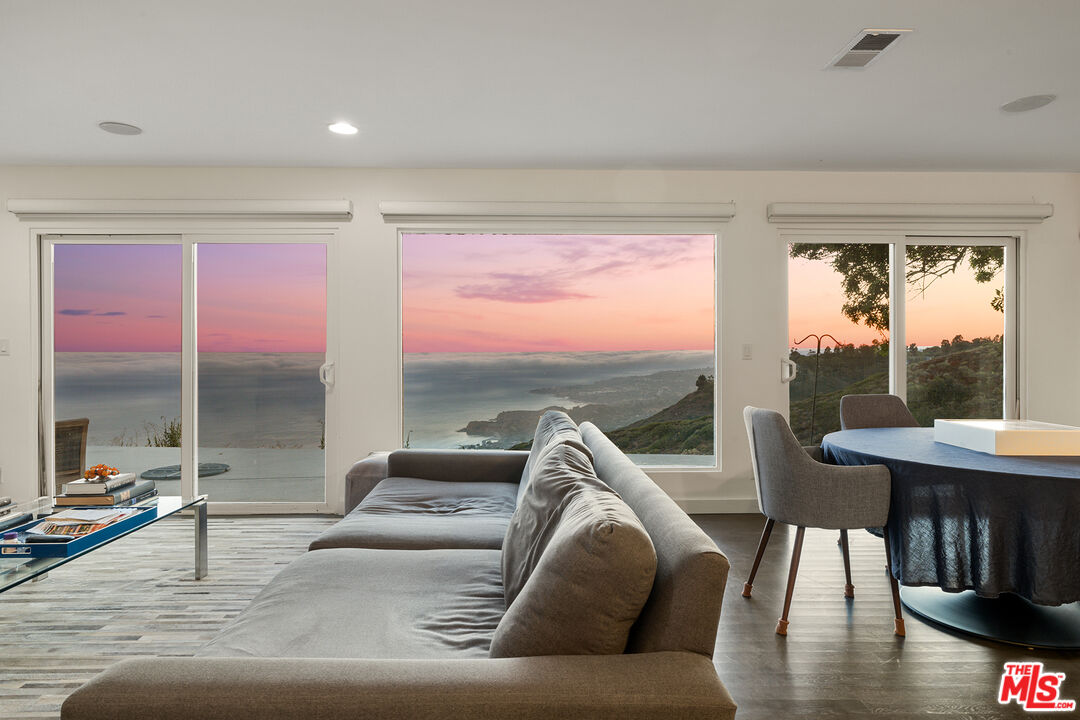 a living room with furniture and a floor to ceiling window