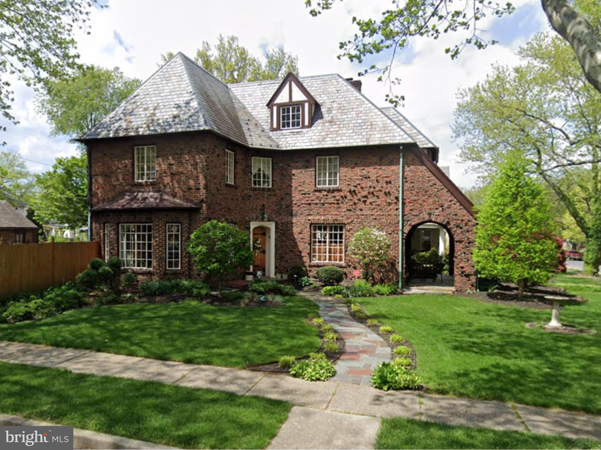 a front view of a house with a garden and plants