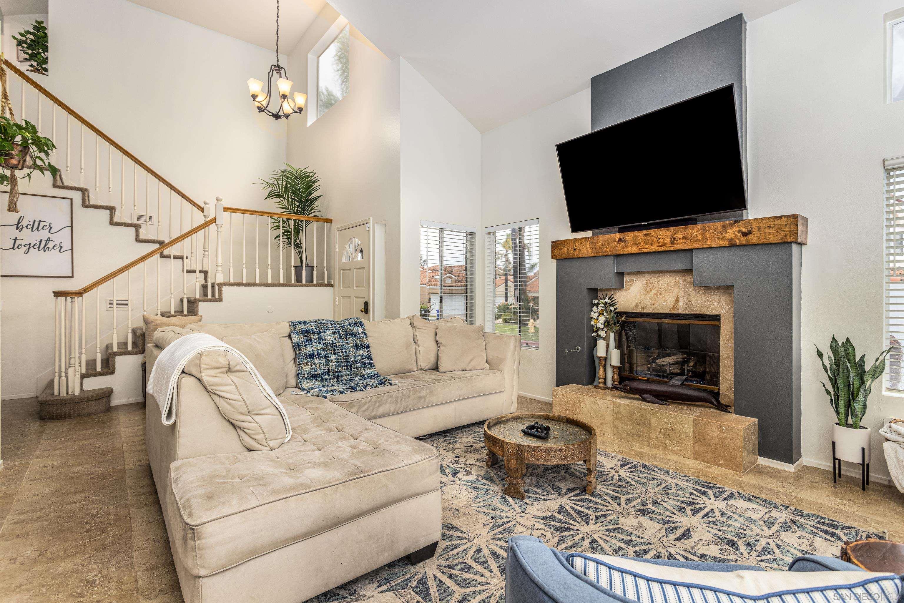 a living room with furniture a flat screen tv and a fireplace