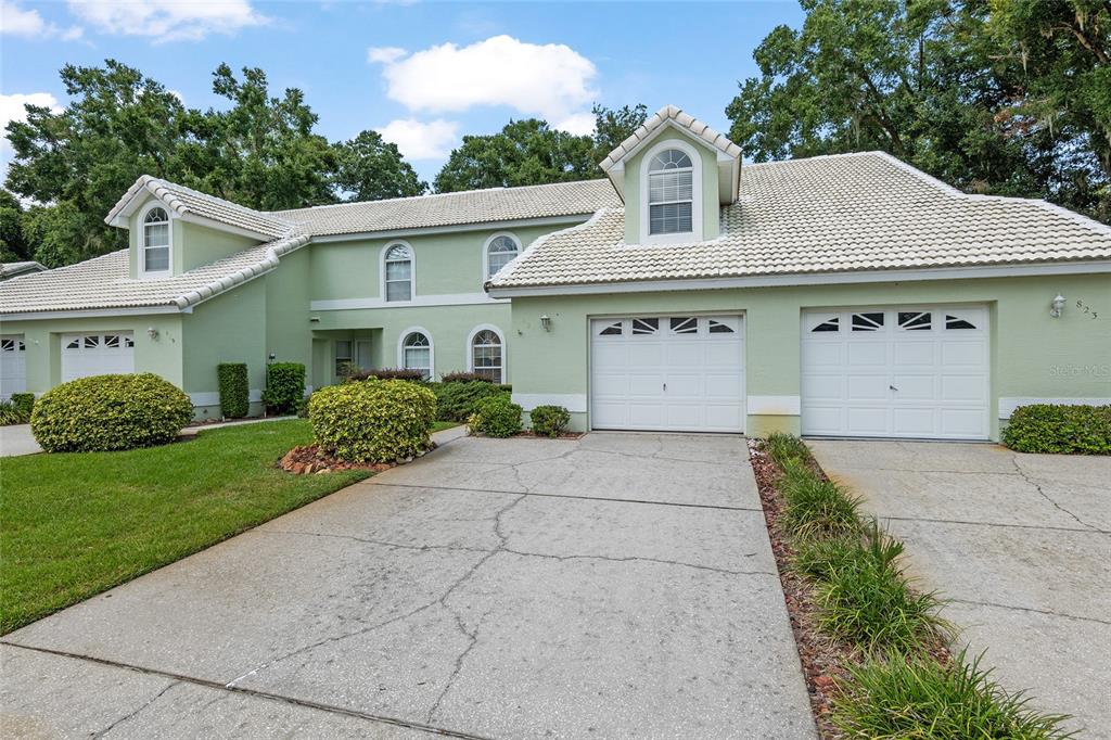 a front view of a house with a yard and trees