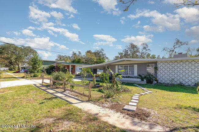 a view of a house with a yard patio and fire pit