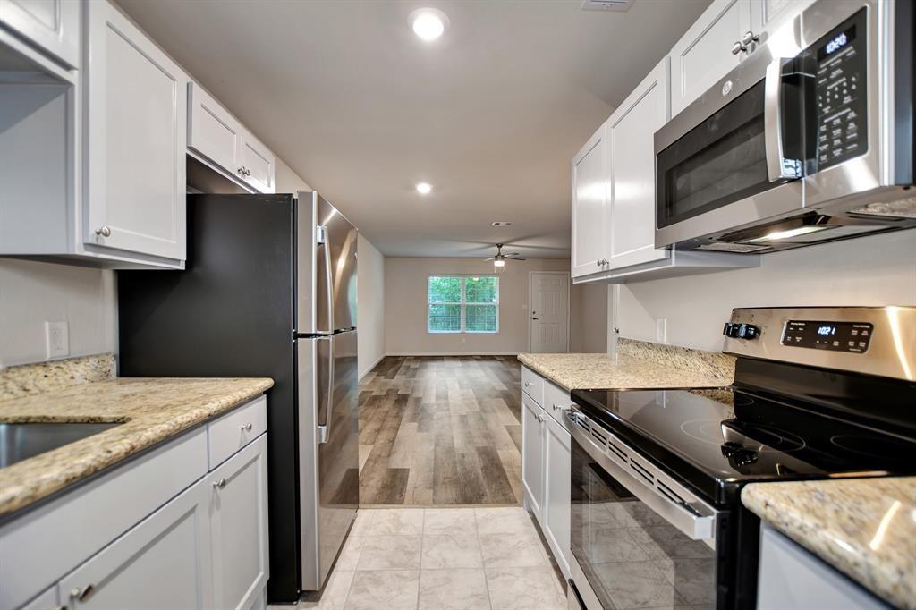 a kitchen with stainless steel appliances granite countertop a sink stove and microwave