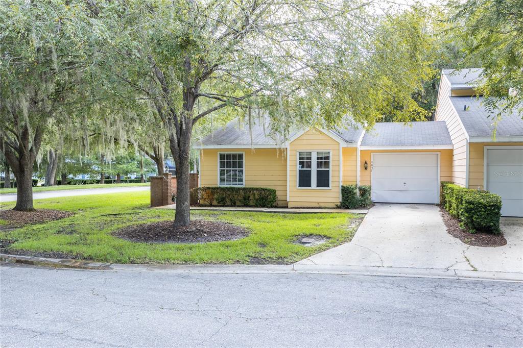 a front view of a house with a yard and trees