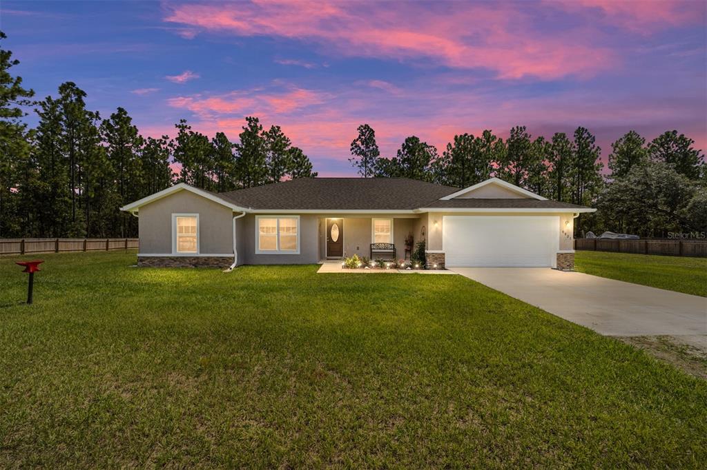 a front view of a house with a yard and trees