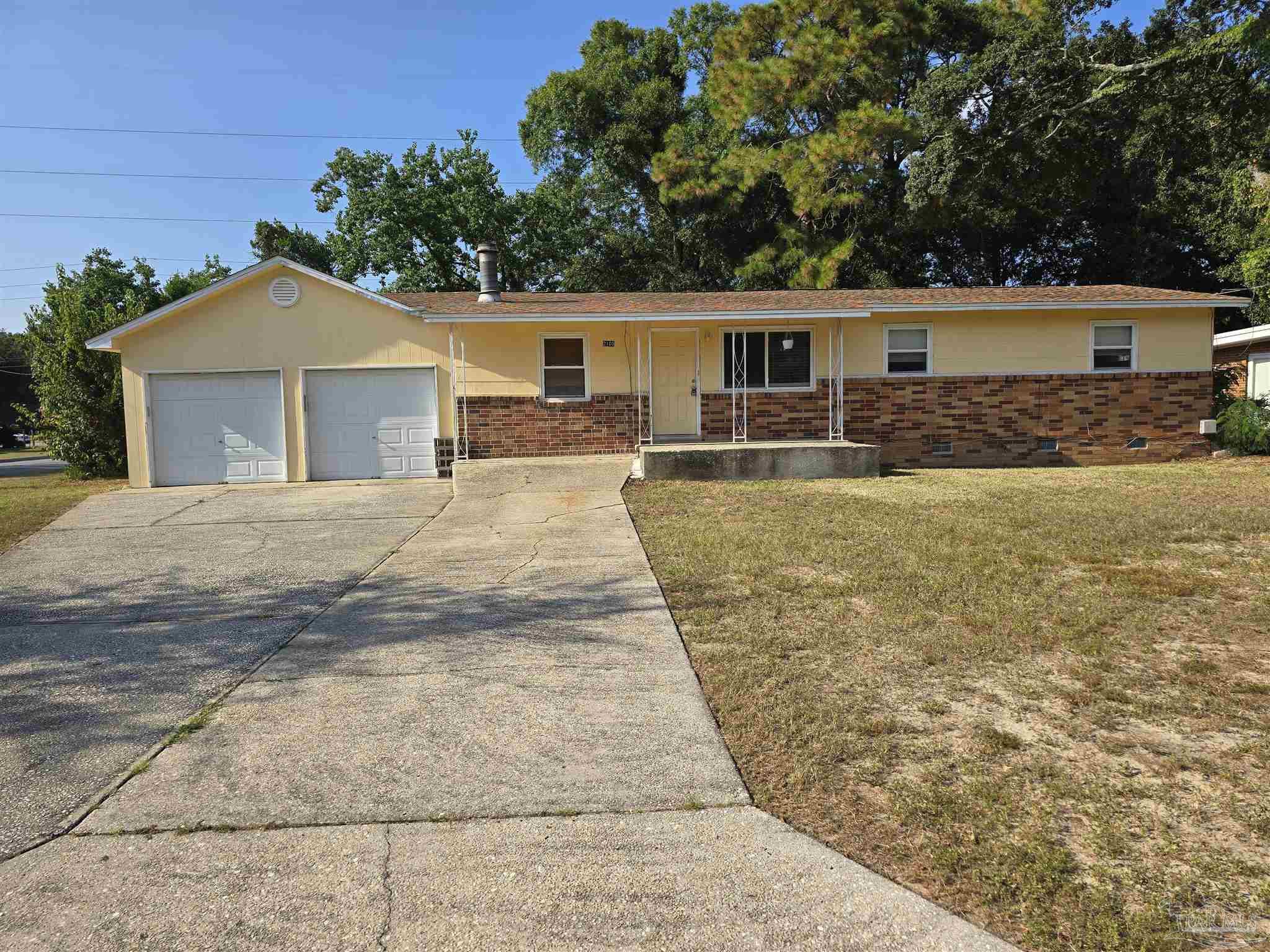 a front view of a house with a yard and trees