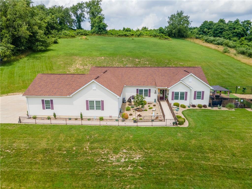 a aerial view of a house with yard and green space