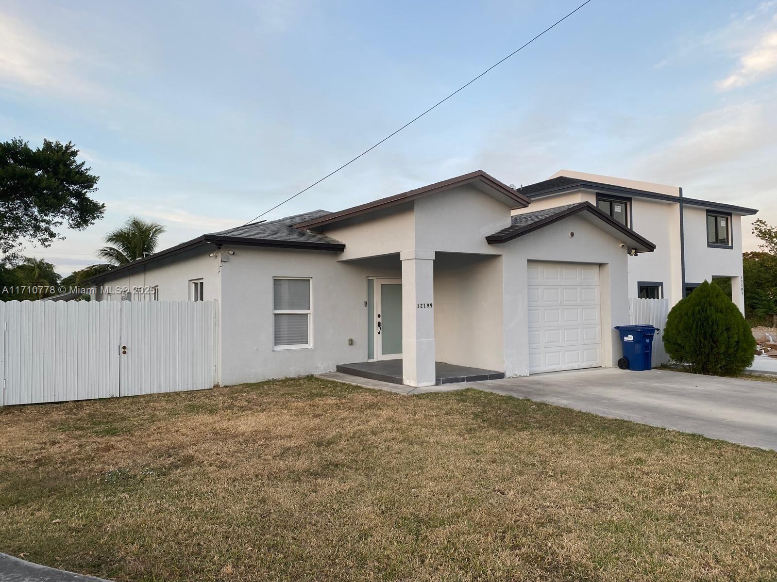 a view of an house with backyard space and garage