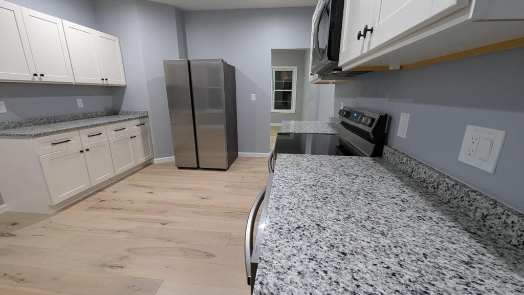 a kitchen with stainless steel appliances granite countertop a refrigerator sink and cabinets