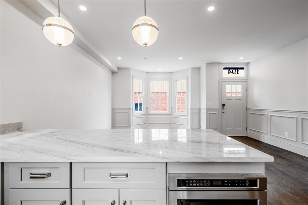 a view of a kitchen with center island and wooden floor