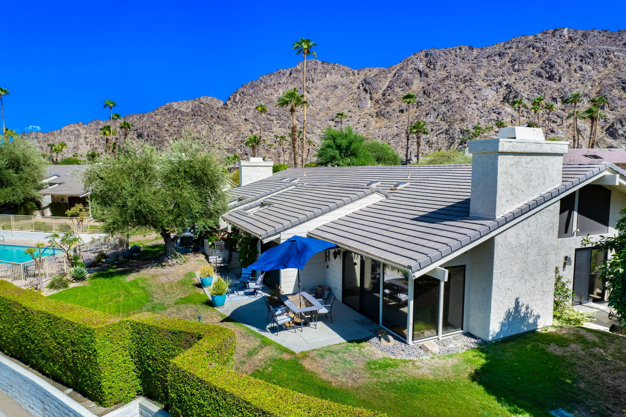 a view of a house with a big yard and sitting area