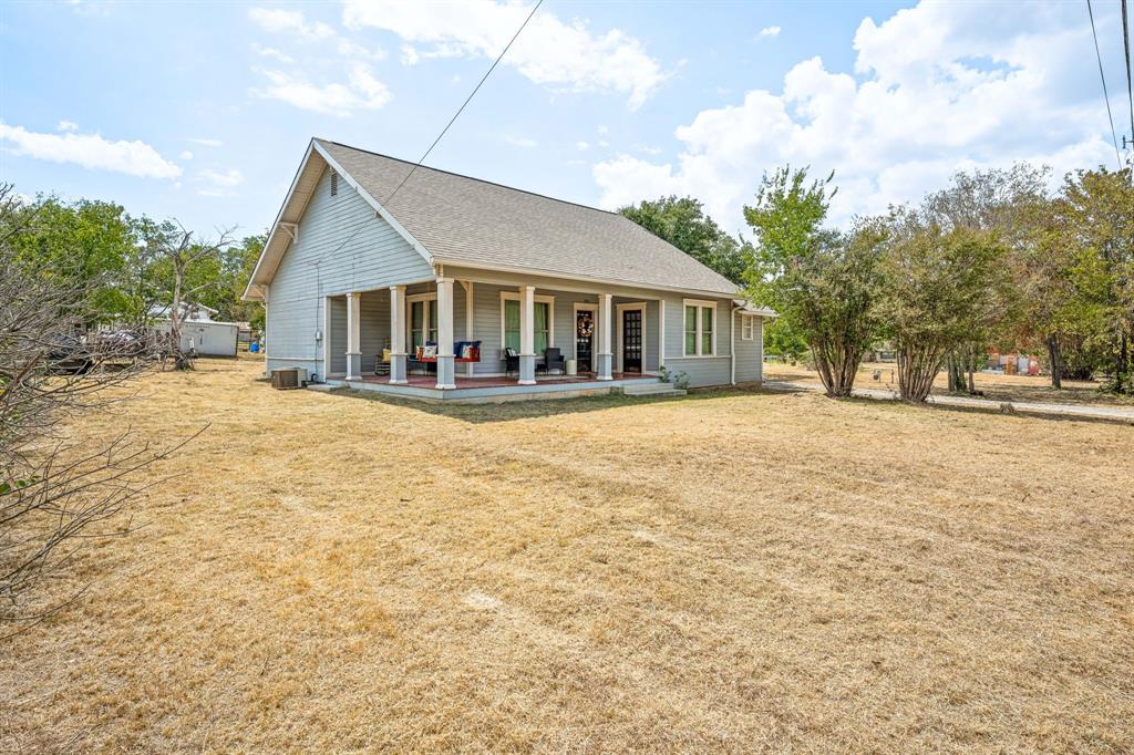 a front view of a house with a yard and lake view