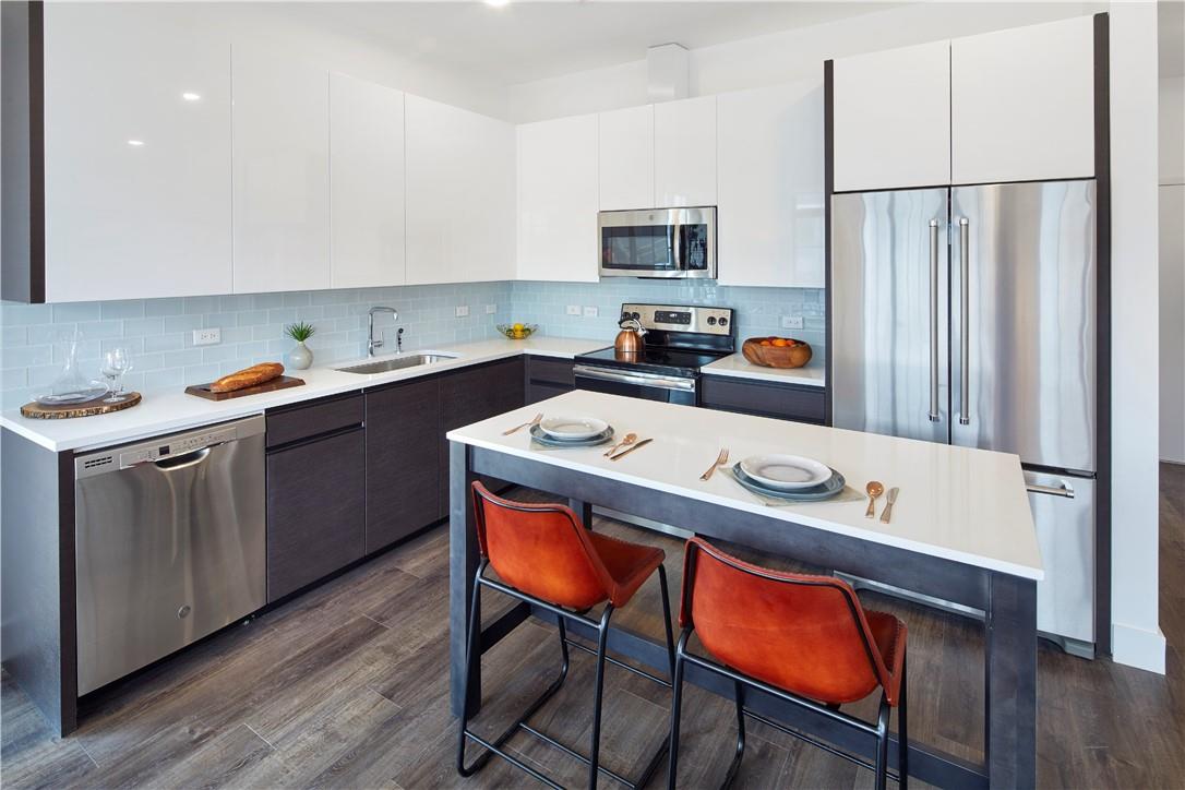 Kitchen with sink, a breakfast bar area, backsplash, and stainless steel appliances