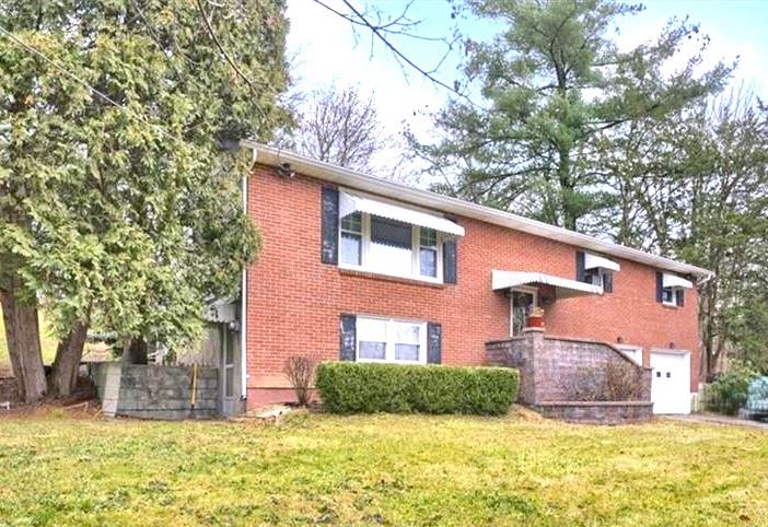 View of front of home featuring a front yard and a garage