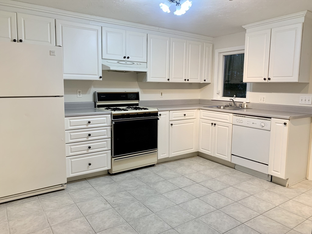 a kitchen with a stove sink and cabinets