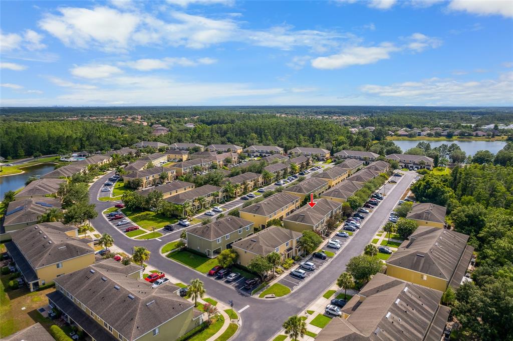 an aerial view of a city with lots of residential buildings ocean and mountain view in back