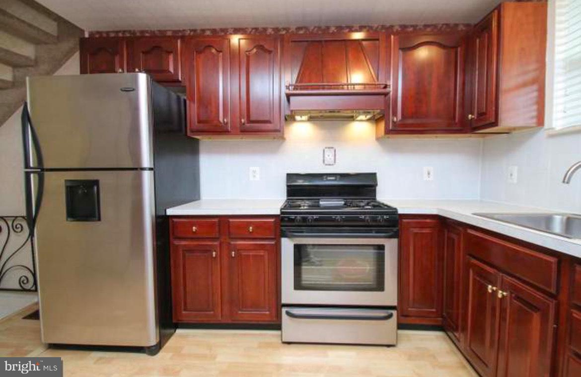 a kitchen with stainless steel appliances granite countertop a refrigerator and a stove