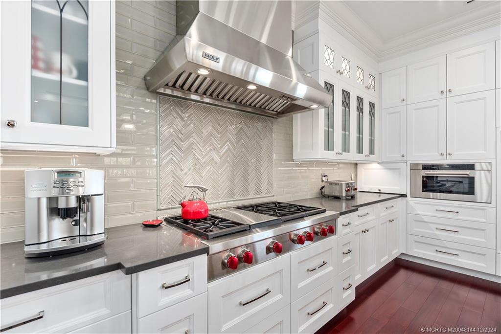 a kitchen with granite countertop a stove and cabinets