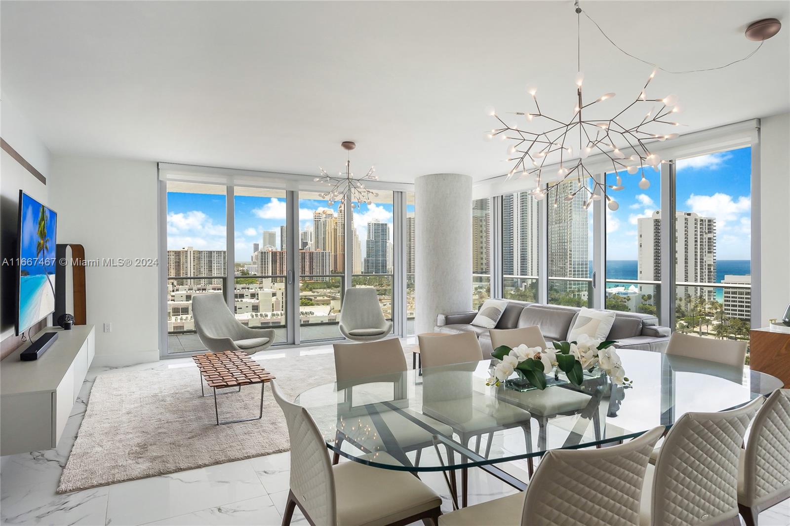 a dining room with furniture a chandelier and large window