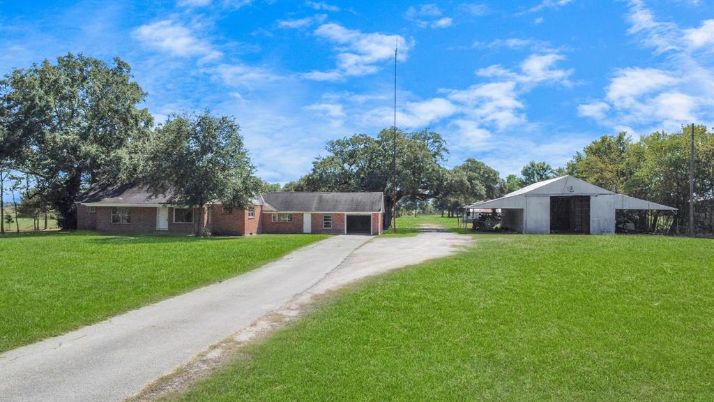 a front view of a house with a yard and trees