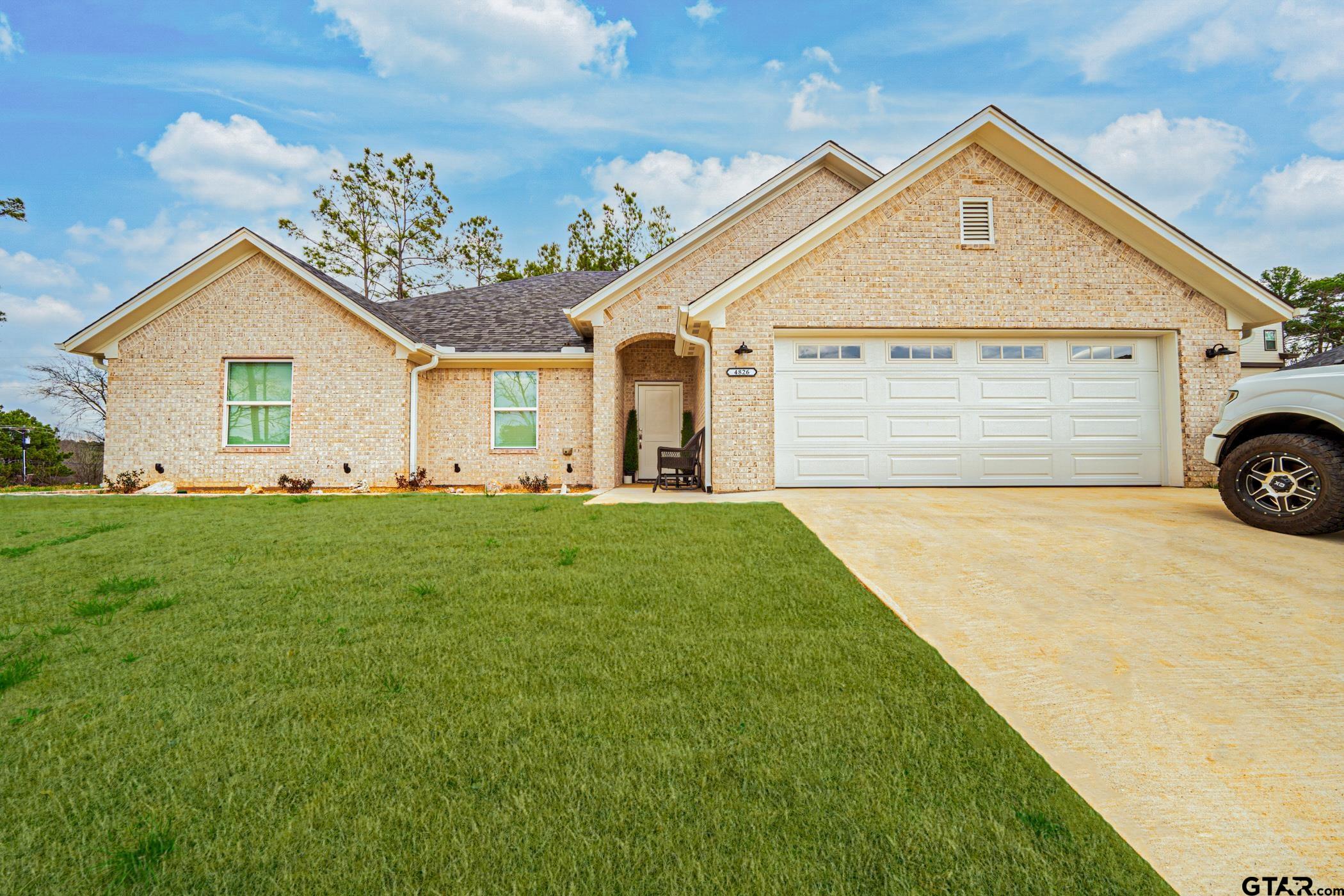 a front view of a house with a garden and yard