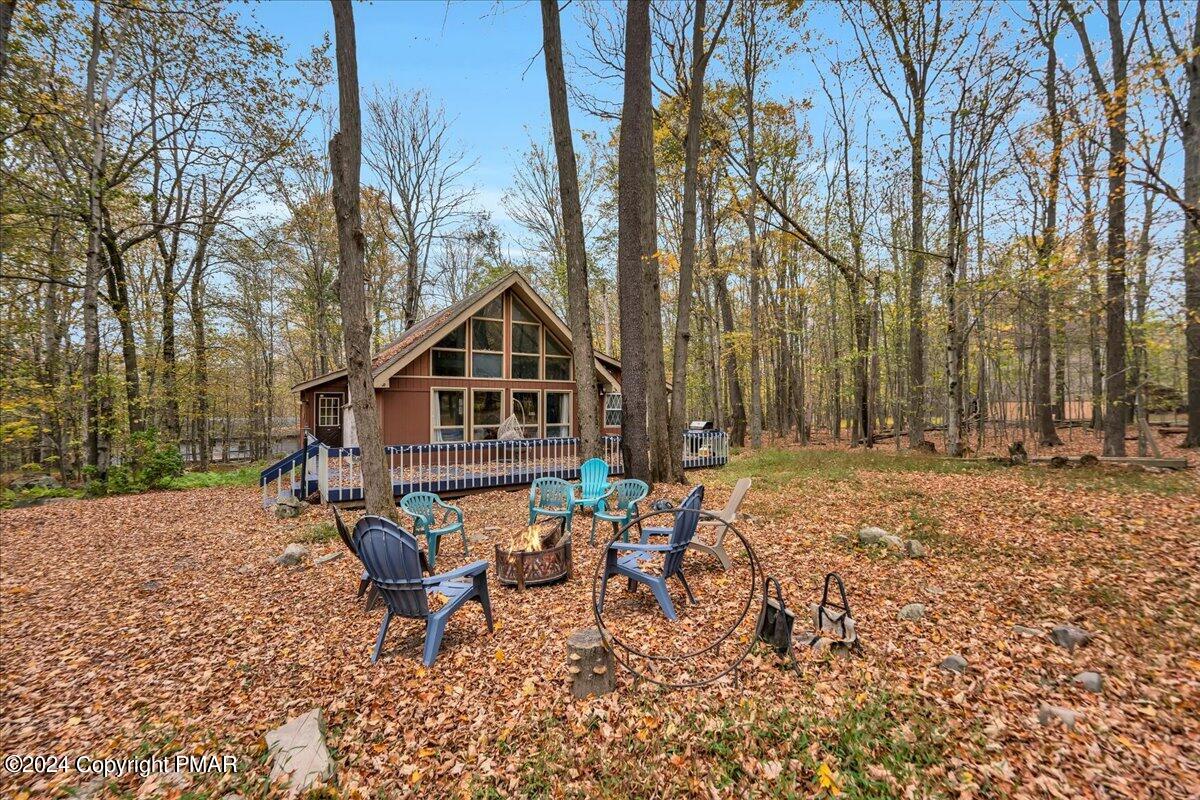 a view of a house with a yard chairs and table in the patio