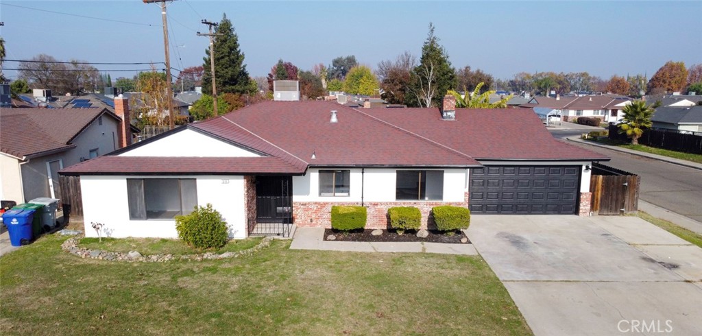 a view of house with a yard and a car park in front of it