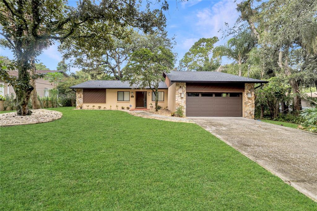 a front view of a house with a yard and trees