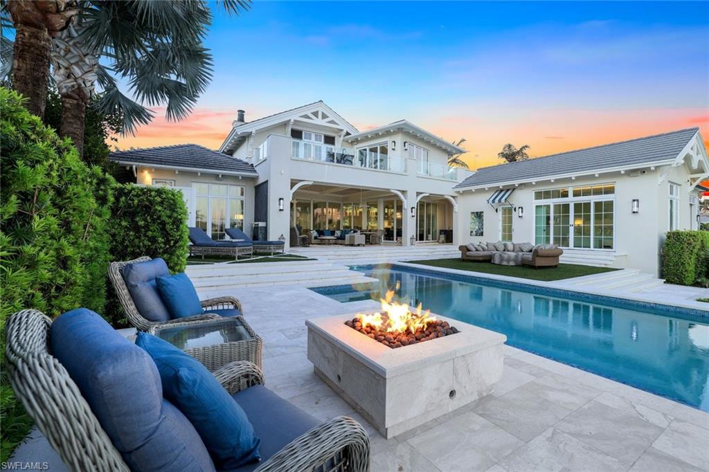 a view of a patio with couches chairs and a swimming pool with a garden and plants