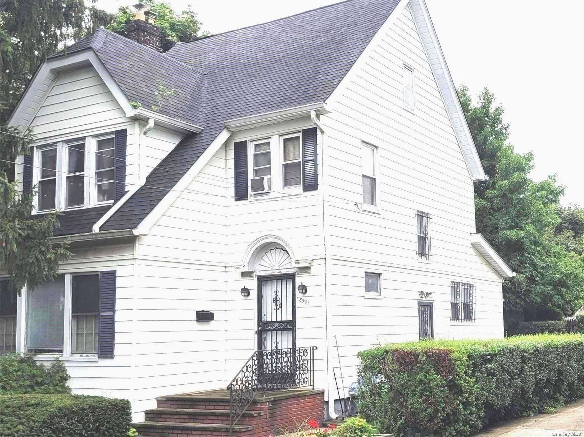 a view of a white house next to a yard