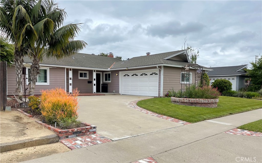 front view of a house with a yard and potted plants