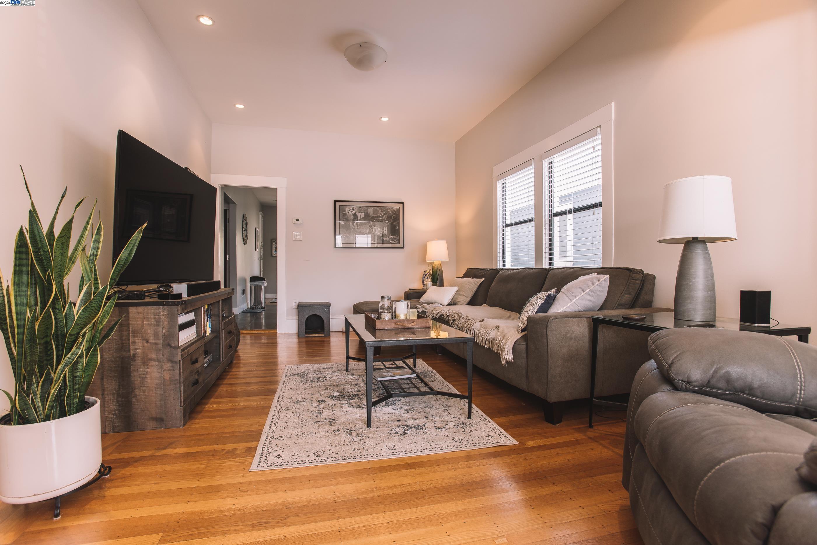 a living room with furniture a flat screen tv and a large window