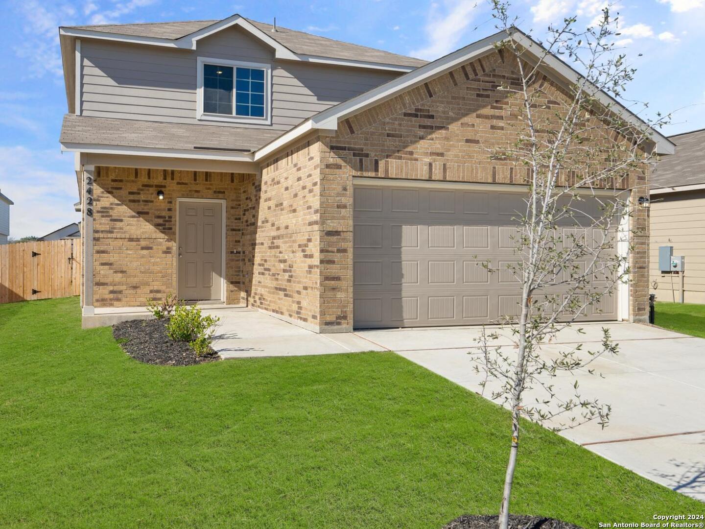 a front view of a house with a garden and yard