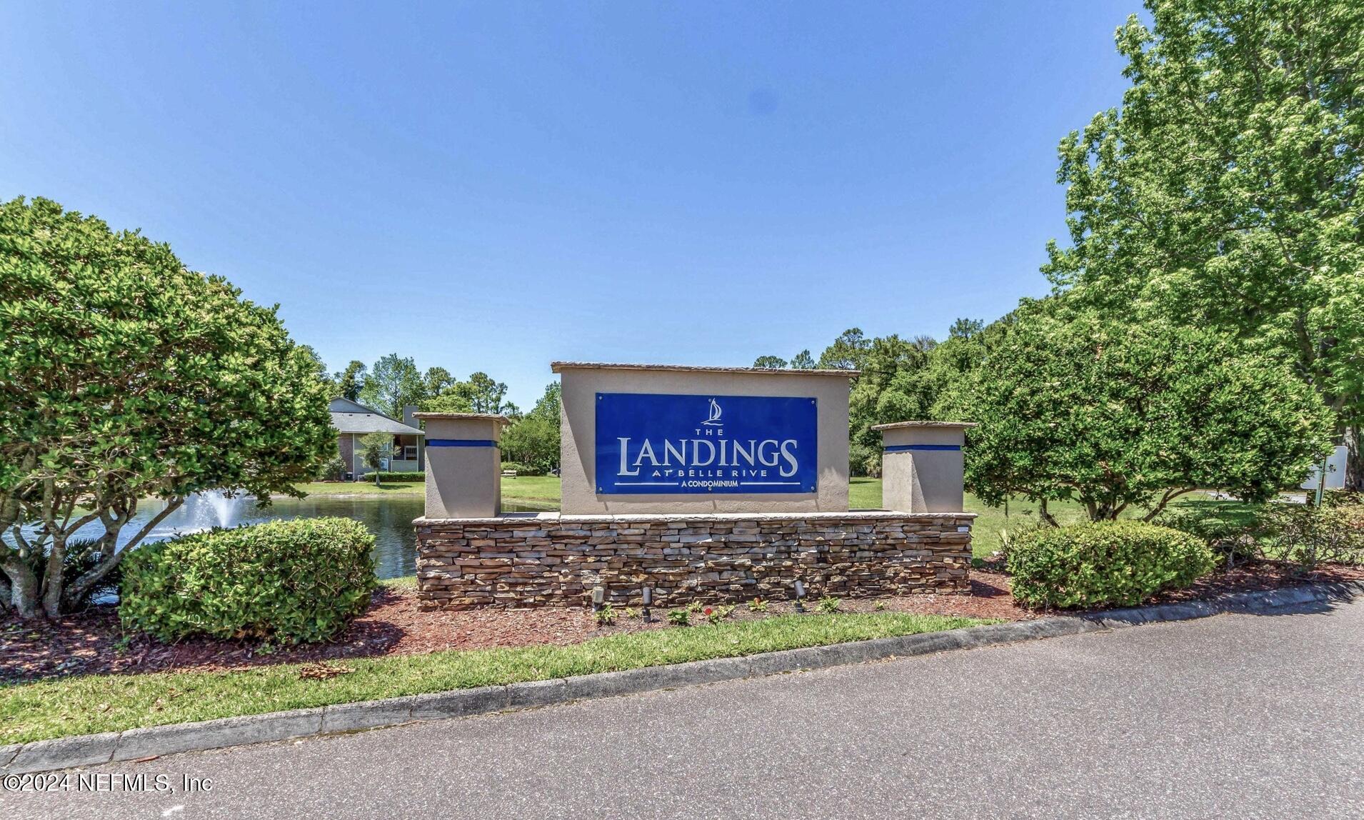 a sign board with a house and yard in the back