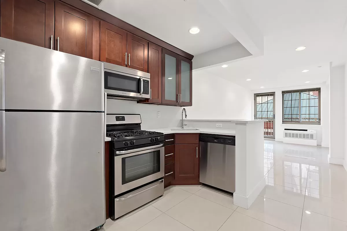 a kitchen with granite countertop stainless steel appliances and refrigerator