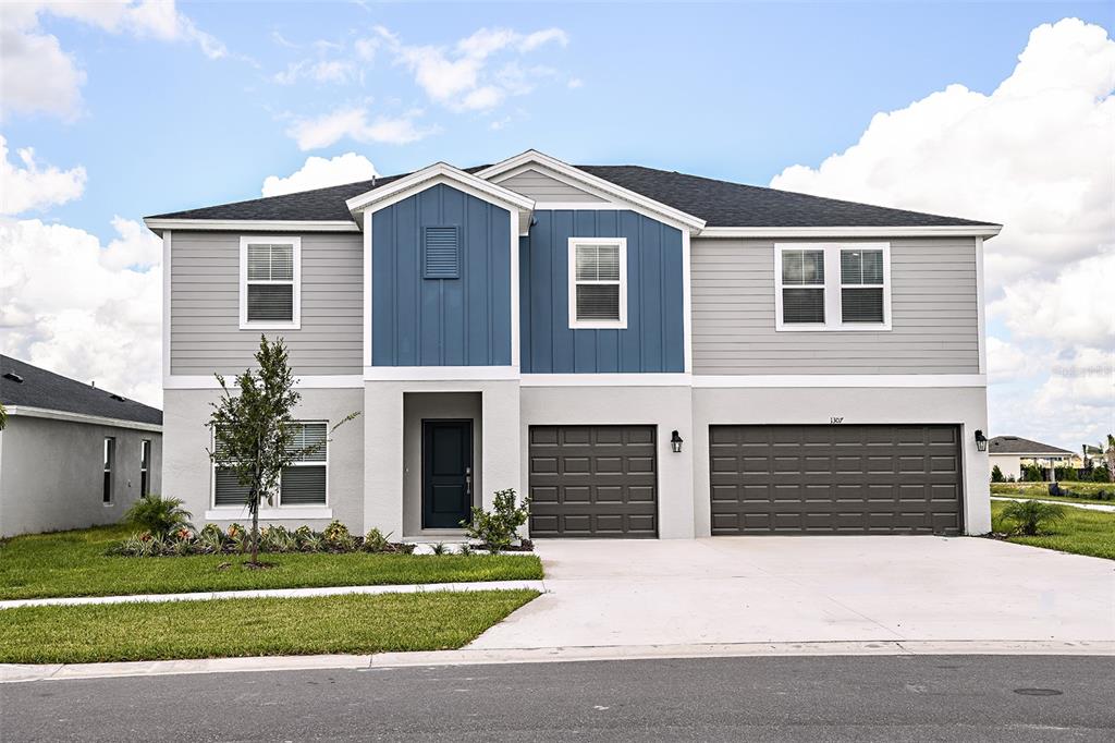 a front view of a house with a yard and garage