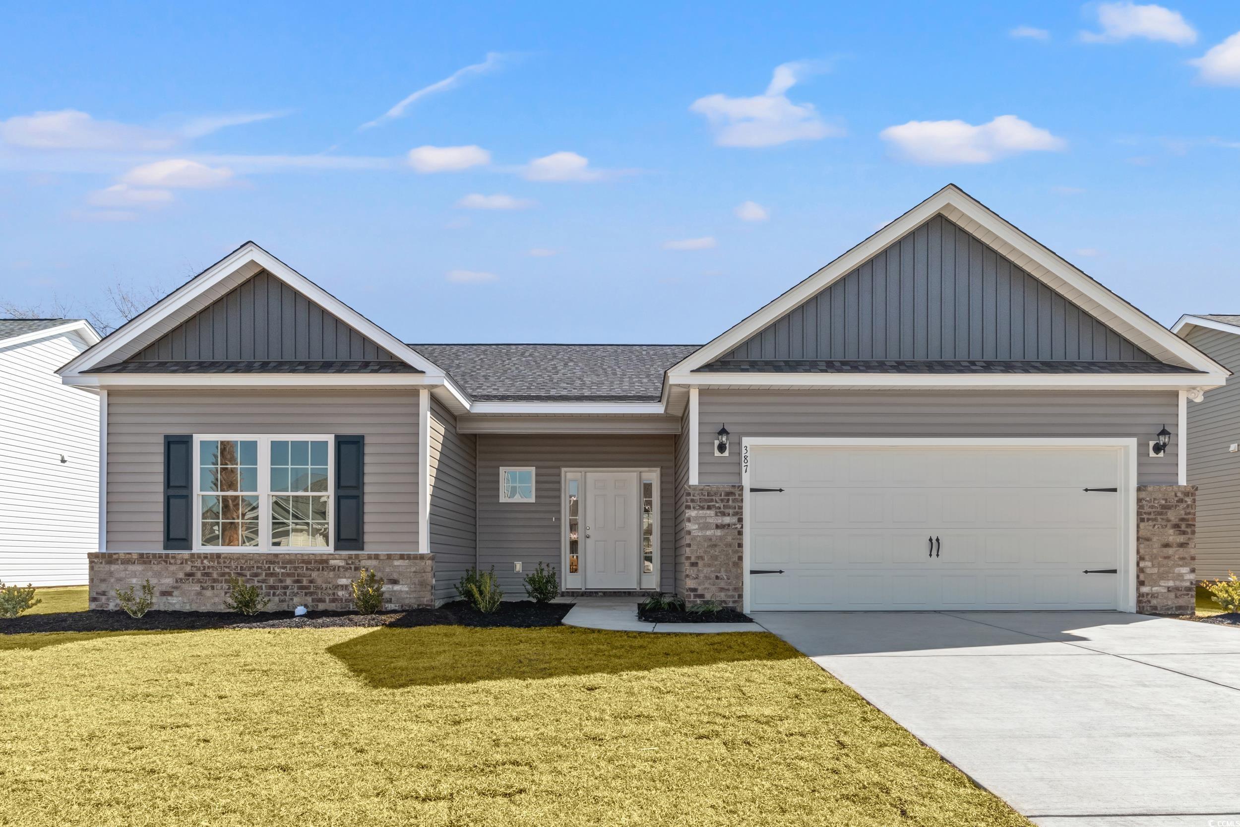 Craftsman house with a garage and a front lawn