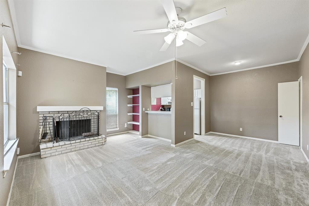 an empty room with fireplace fan and windows