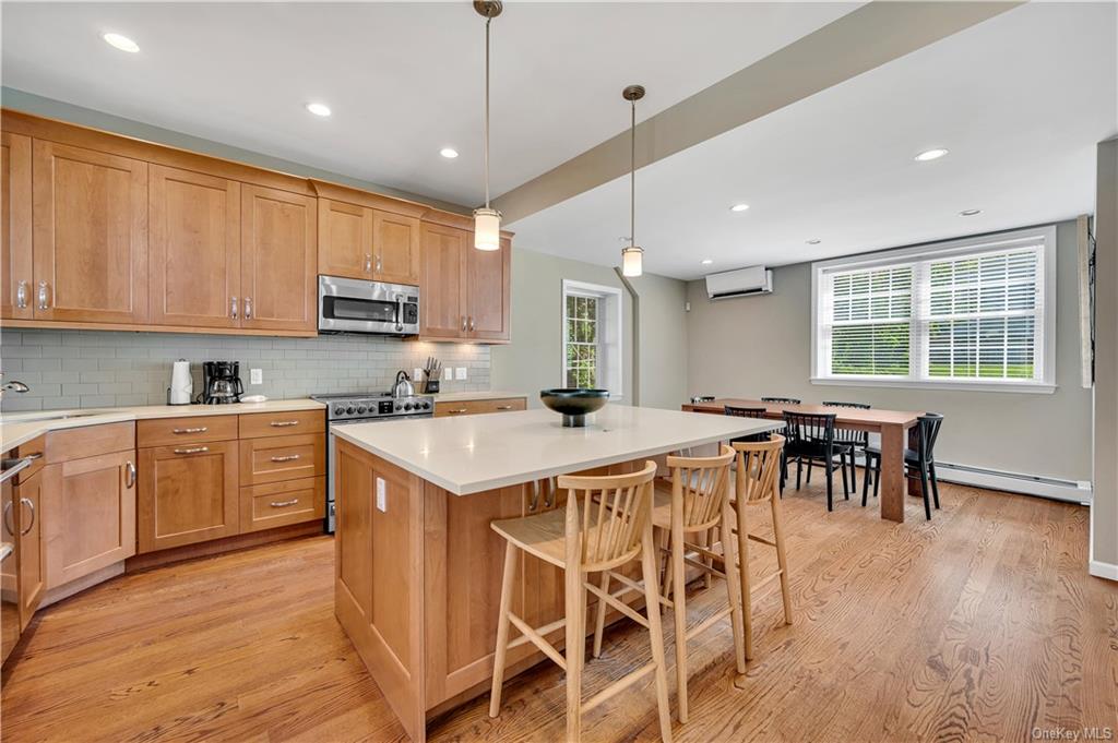 Kitchen with light wood-type flooring, stainless steel appliances, plenty of natural light, and a center island