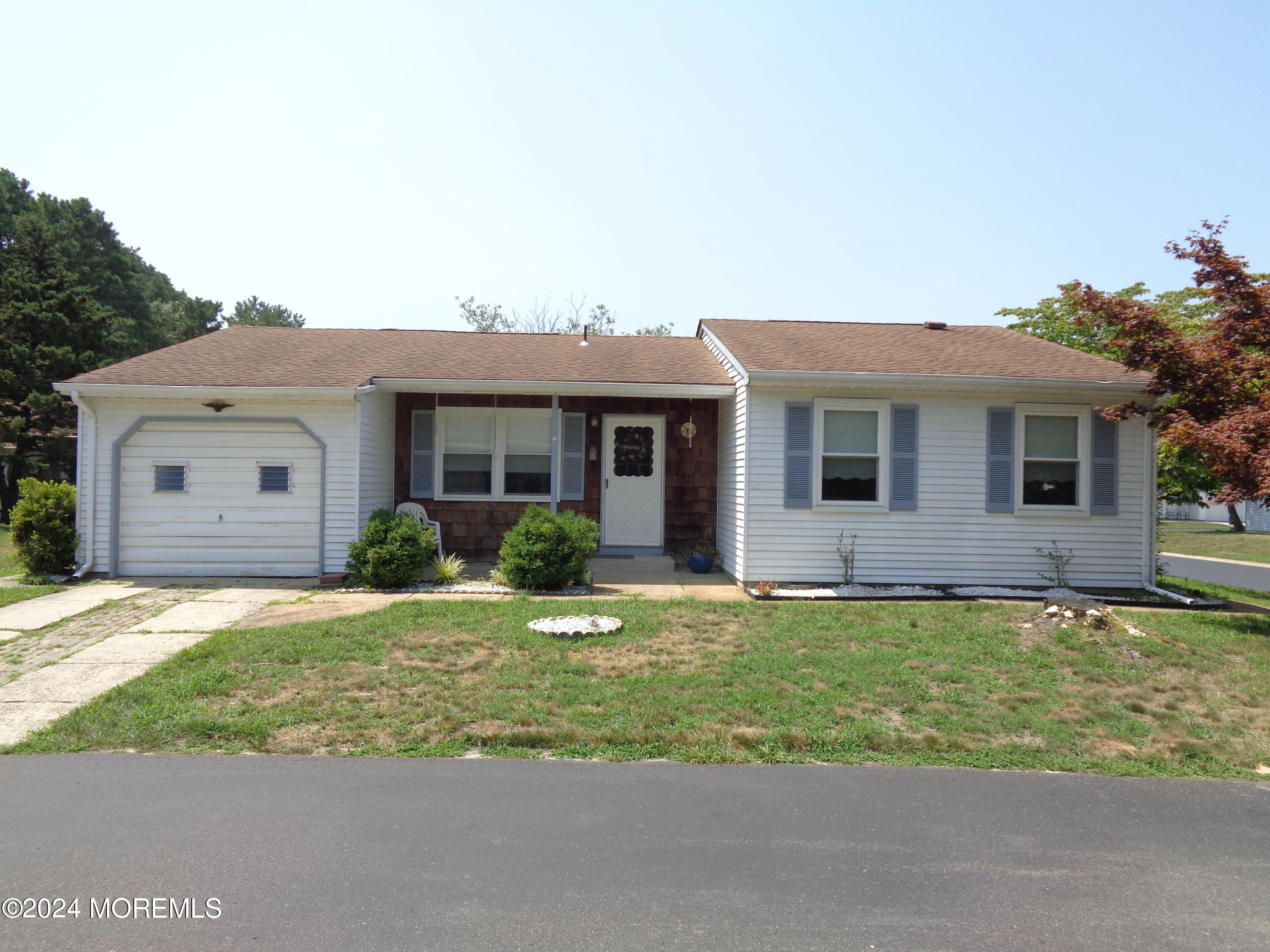 a front view of a house with a garden and yard