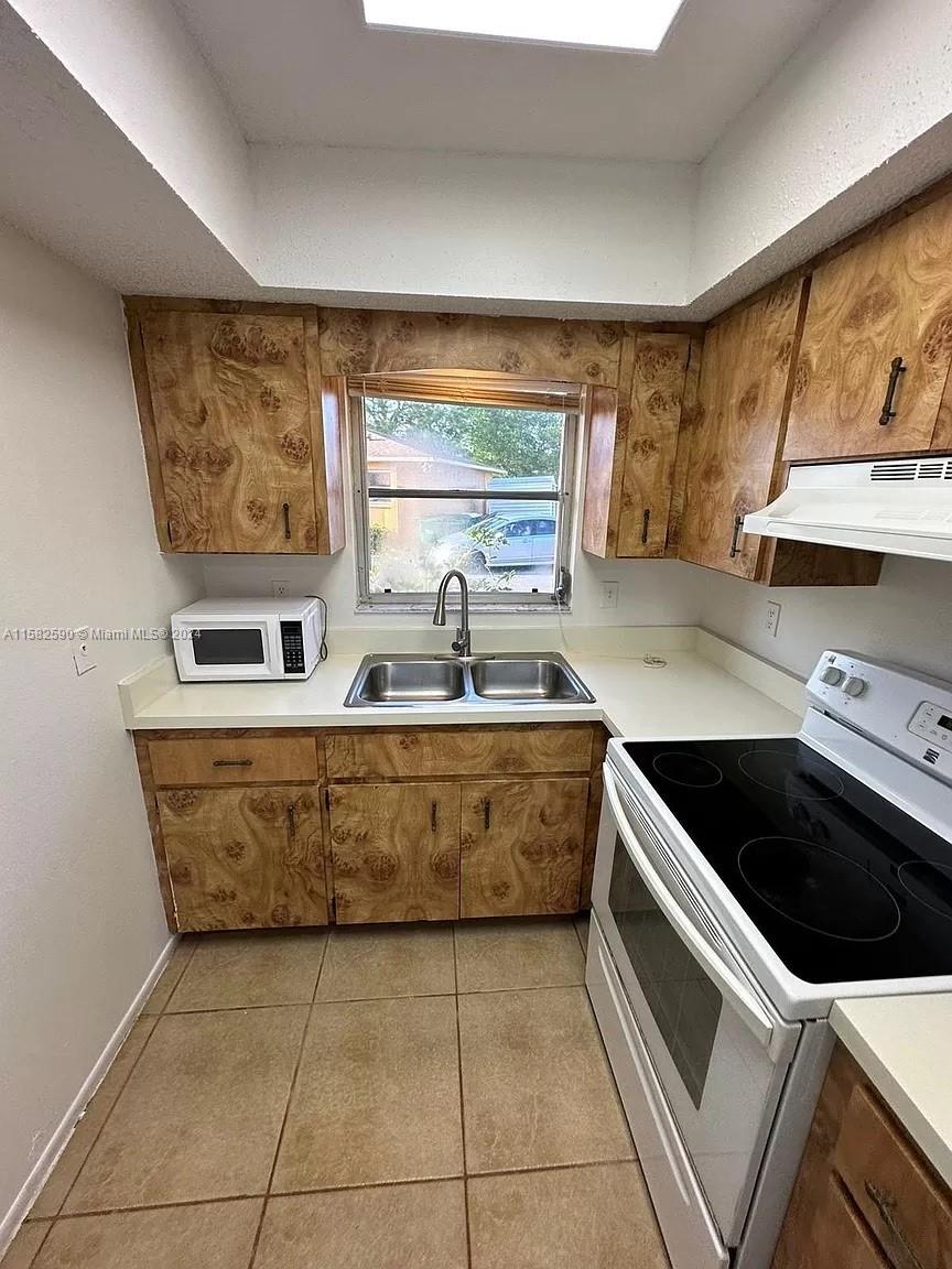 a kitchen with a sink a stove and cabinets